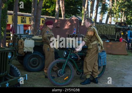 Holt, Norfolk, Großbritannien – 21. SEPTEMBER 2024: Männer in Uniformen der 1940er Jahre neben einem klassischen Militärmotorrad Stockfoto