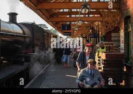 Sheringham, Norfolk, Vereinigtes Königreich - 21. SEPTEMBER 2024: Menschen mit Vintage-Kleidung der 1940er-Jahre laufen am Wochenende der 1940er-Jahre auf dem Bahnsteig neben der Dampflokomotive Stockfoto