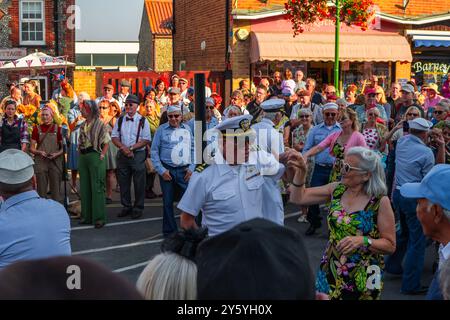 Sheringham, Norfolk, Großbritannien - 21. SEPTEMBER 2024: Foto von Menschen in Vintage-Kleidung der 1940er Jahre, die während des Wochenendes der 1940er vor Menschenmassen auf der Straße tanzten Stockfoto
