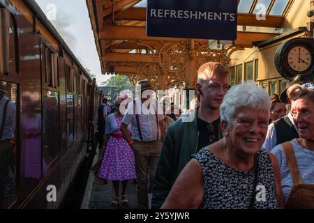 Sheringham, Norfolk, Vereinigtes Königreich - 21. SEPTEMBER 2024: Menschen mit Vintage-Kleidung der 1940er-Jahre laufen am Wochenende der 1940er-Jahre auf dem Bahnsteig neben der Dampflokomotive Stockfoto