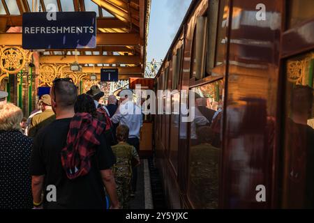 Sheringham, Norfolk, Vereinigtes Königreich - 21. SEPTEMBER 2024: Menschen mit Vintage-Kleidung der 1940er-Jahre laufen am Wochenende der 1940er-Jahre auf dem Bahnsteig neben der Dampflokomotive Stockfoto