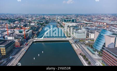 Luftdrohnenaufnahme des Stadtzentrums von Dublin mit einer berühmten weißen Brücke, die den Fluss mit belebten Straßen und Wahrzeichen überspannt. Stockfoto