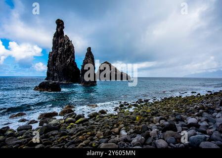 Der atlantik stürzt an einem bewölkten Tag mit ruhigem Meer und grauen Wolken an der Nordküste Madeiras nahe Seixal M auf die Felsen und die Küste Madeiras Stockfoto