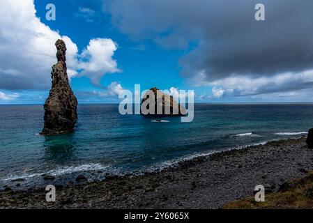 Der atlantik stürzt an einem bewölkten Tag mit ruhigem Meer und grauen Wolken an der Nordküste Madeiras nahe Seixal M auf die Felsen und die Küste Madeiras Stockfoto