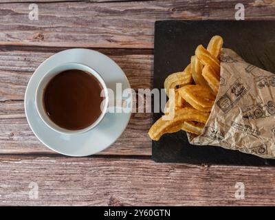 Blick von oben auf eine Tasse heiße Schokolade mit Churros auf Holztisch Stockfoto