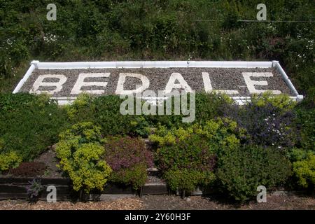 Bedale Station Schild in Blumenbeeten, Wensleydale Heritage Railway Leeming nach Leyburn, Yorkshire Dales, England Stockfoto