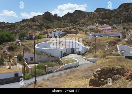 Blick auf das sonnige Dorf mit weißen Häusern und felsiger Landschaft im Sommer, Höhlenwohnungen, Höhlenviertel, Troglodytos, Barrio de Cuevas, Guadix, Granada Prov Stockfoto