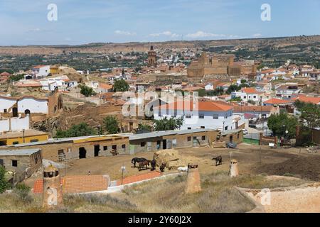 Blick auf das ländliche Dorf mit Häusern, Pferden und Hügeln in einer Sommerlandschaft, Höhlenwohnungen, Höhlenviertel, Troglodytos, Barrio de Cuevas, Guadix, Gra Stockfoto