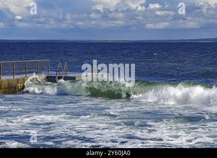 Wellen, die gegen ein Geländer im Meer unter wolkenblauem Himmel Rollen, Toensberg, Oslofjord, Norwegen, Europa Stockfoto