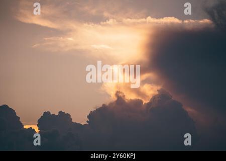 Dramatischer Sonnenuntergangshimmel mit dunklen Wolken und goldenem Licht, das durchbricht und einen atemberaubenden Kontrast schafft Stockfoto