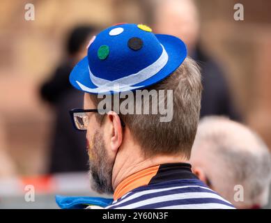 Freiburg im Breisgau, Deutschland - 12. Februar 2024: Maskerade. Ein Mann mit einem blau verzierten Karnevalshut Stockfoto