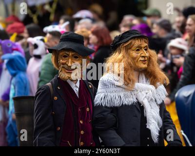 Freiburg im Breisgau, Deutschland - 12. Februar 2024: Maskerade. Wunderschöne Masken in einer Karnevalsparade mit verschwommenen Menschen im Hintergrund. Stockfoto