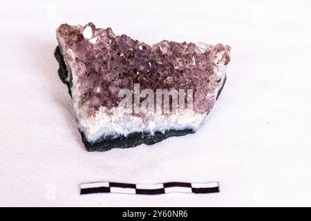 Kristalle einer Amethyst-Geode auf weißem Hintergrund mit einer Skala von 5 cm Stockfoto