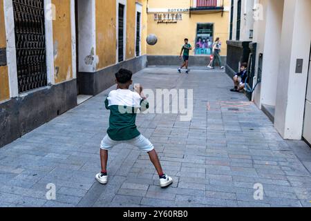 Kinder spielen Fubol in den Straßen von Sevilla, Spanien. Stockfoto