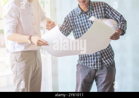 Architect erstellt Pläne für Ingenieure, um die Baupläne vor dem Bau zu prüfen und die Baukosten korrekt zu berechnen. Gemeinsame Blueprint-Überprüfung Stockfoto