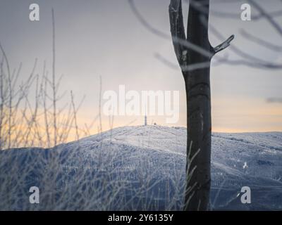 Malerische Winterlandschaft mit schneebedeckten Bergen und einem ruhigen Sonnenuntergangshimmel, die eine ruhige und malerische Atmosphäre in Ungarn, Mátra, Ké schafft Stockfoto