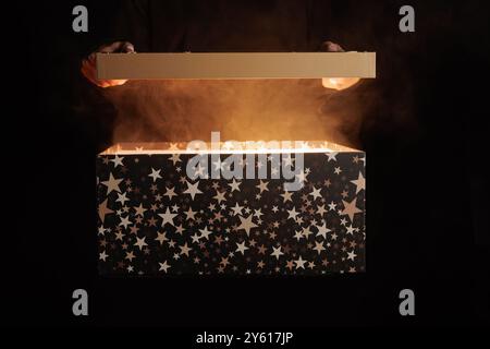 Magische Überraschungsbox auf dunklem Hintergrund mit Rauch, Rabatt- und Verkaufskonzept, magisches Geschenk Stockfoto