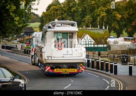 Ein großer Lastwagen, der mit einer breiten Ladung durch Windermere im Lake District aufwacht Stockfoto