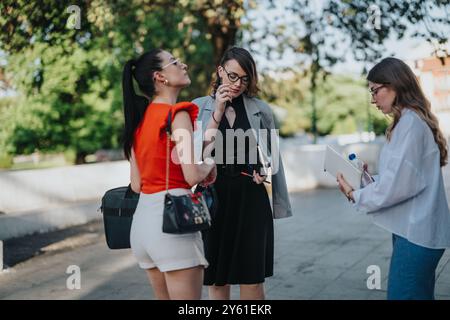 Gruppe von Geschäftsfrauen, die sich im Freien mit Notizbüchern unterhalten Stockfoto