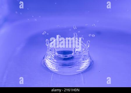 Minimalistische Fotografie, von einem Wassertropfen, einem Spritzer, einer Welle, die sich auf der Wasseroberfläche ausbreitet, Bild, das Ruhe, Meditation, Ruhe anregt Stockfoto