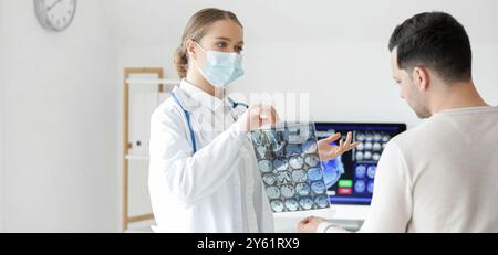 Ärztin zeigt mrt-Aufnahmen an Patienten in der Klinik Stockfoto