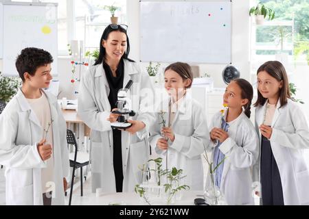 Schüler und Lehrer mit Mikroskop im Biologiekurs Stockfoto