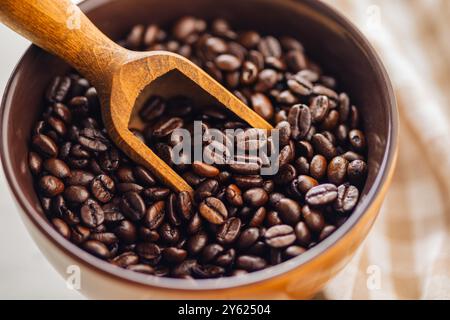 Geröstete Kaffeebohnen in einer Schüssel auf einem weißen Tisch. Stockfoto