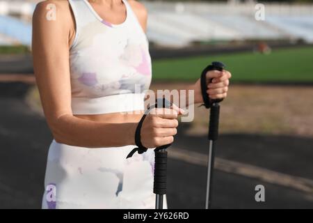 Schöne reife Frau, die mit Gehstöcken im Stadion trainiert, Nahaufnahme Stockfoto