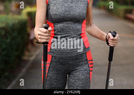 Schöne reife Frau trainiert mit Wanderstöcken im Park, Nahaufnahme Stockfoto
