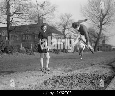 Mitcham, das für die bevorstehenden Olympischen Spiele ausgebildet wird, ist auf dem News of the World Sports Ground beschäftigt und sind Mädchen aus allen Bereichen des Lebens, von Bankbeamten bis zu Hausfrauen. Sie stehen unter dem wachsamen Auge von Mrs. M. Cornell, Trägerin der britischen Langsprungrekord und offizieller Olympiasieger. Unter ihren Augen übt Lorna Cornell Long Jumping auf Mitcham. 25. Januar 1948 Stockfoto