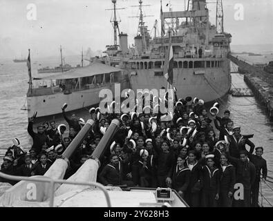 Indische Marineoffiziere und Offiziere, die den Kreuzer H.M.S. Achilles für die Royal Indian Navy übernehmen sollen, kamen in Portsmouth in den Sloops H.M.I.S. Kisna und H.M.I.S. Cauvery an. Die Schiffsgesellschaften werden Kurse in R.N.-Einrichtungen absolvieren, bevor sie H.M.I.S. Achilles in Betrieb nehmen. Foto zeigt: Eine allgemeine Ansicht von jubelnden indischen Seeleuten an Bord der H.M.I.S. Kristna in Portsmouth. Im Hintergrund stehen HMS Diadem und HMS Woolfe. 16. Januar 1948 Stockfoto