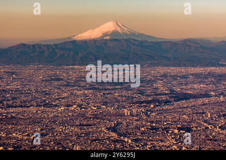 Aus der Vogelperspektive auf den schneebedeckten Fuji und Tokio bei Sonnenaufgang Stockfoto