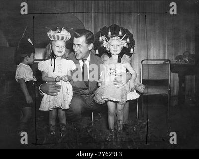 Filmschauspieler Stewart Granger posiert mit der vierjährigen Tania Heald (links), die mit ihrem Kopfschmuck mit Orangen und Zitronen den ersten Preis gewann, und dem dreijährigen Hazel Rubens, der heute mit „vier und 20 Blackbirds gebacken in einem Kuchen“ auf der Kinderparty zugunsten der Sunshine Homes for the Blind im Dorchester Hotel an zweiter Stelle stand. Herr Granger fungierte als Richter im Kopfgeldwettbewerb. 30. Dezember 1947 Stockfoto