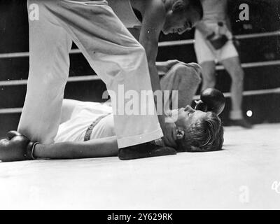 Obwohl Großbritannien das Amateurboxspiel mit Dänemark im Wembley Empire Pool mit einem 5:3-Sieg gewann, zeigten die dänischen Boxer am Abend eine gute Präsentation von Ringbooten. Dänemark gewann das Fliegengewicht und die Federgewichte sowie die Weltergewichtskämpfe, während die Heimmannschaft den Rest der Karte absetzte. Das Bild zeigt: "Out by the Bell" der 19-jährige G. Hansen von Dänemark lügt vom britischen F.. Glocke in der ersten Runde des Schwergewichtswettbewerbs. 27. November 1947 Stockfoto