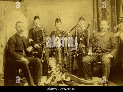 ARCHIVBOX 3 ARC 0086 D590 REFERENZ: 000138 MUSIKALISCHE JUNGS GRUPPE DATUM : C 1890S REV . MAYERS MIT EINIGEN DER MUSIKALISCHEN JUNGS : DREI JUNGS IM HIGHLAND-KLEID MIT DUDELSACK . EIN JUNGE MIT EINEM EIMER Stockfoto