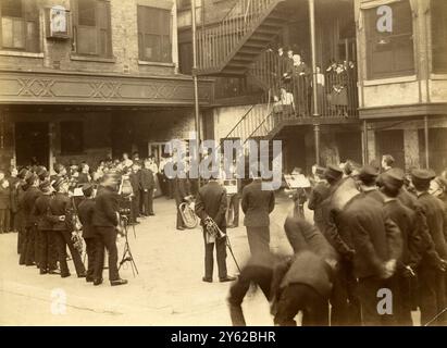 ARCHIVBOX 2 ARC 0032 D111 REFERENZ: 001333 EMPIRE DAY IM STEPNEY BOYS HOME C 1912 BOYS BAND IM HOF : MR. WILLIAM BAKER SPRICHT MIT JUNGS AUS DER EISERNEN TREPPE Stockfoto