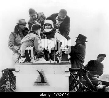 Die United Air Force gab am Montag 27.12.1954 bekannt, dass Lt. Col. John P. Stapp einen neuen Geschwindigkeitsrekord von 632 km/h in einem Raketenschlitten erreicht hat. Das Foto zeigt in letzter Minute Anpassungen, die von den Flugzeugtechnikern der US Airforce und Northrop vorgenommen wurden, um Stapp an seinem Sitz zu sichern. Er trägt ein spezielles Nylongeschirr und helmut aus Kunststoff mit einem transparenten Kunststoffvisier, um Kopf und Gesicht zu schützen. New Mexico - 29. Dezember 1954. Stockfoto