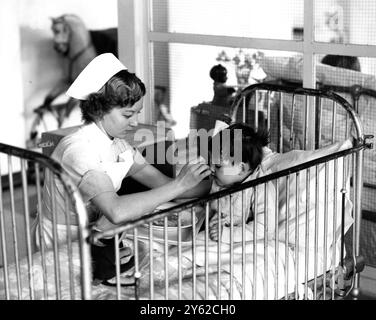 Ein Bild aus einer Serie von Schülerinnen und Schülern, fotografiert im Kent and Canterbury Hospital in Canterbury, Kent, England . Das Bild zeigt eine Studentenschwester, die einem kranken kleinen Jungen eine Mahlzeit füttert. 3. Juli 1954 Stockfoto