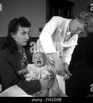 Mit der Einführung des Nationalen Gesundheitsdienstes im Juli 1948 kann diese junge Mutter nun kostenlos für ihr Baby gesundheitlich versorgt werden . Dies hat vielen jungen Familien in der Gegend von Bootle in der Nähe von Liverpool geholfen, deren Leben von Armut und Armut heimgesucht wird. September 1948 Stockfoto