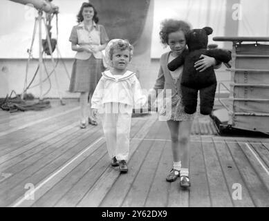 Terence (drei Jahre alt) und Maureen (viereinhalb Jahre alt) Johnson mit ihrer Mutter Eileen Johnson (24 Jahre alt) an Bord der HMT Empire Windrush in Tilbury Docks. 22. Juni 1948 Hinweis: Der schwarze Teddy ist ein Titanic Commemoration Bär. Diese Bären wurden zum Gedenken an diejenigen geschaffen, die 1912 bei der Versenkung der Titanic starben. Stockfoto