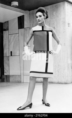 Paris: Eines der markantesten Ensembles in der abstrakten Stimmung, die Yves Saint-Laurent für seine Herbst-Winter-Kollektion 1965 ins Leben gerufen hat, ist diese Kreation. Der Deckmantel ist in reinem weißen Melton Cloth, das Kleid in weißem Jersey und erinnert an die Malerei von Mondrian. Er ist aus weißem Jersey gefertigt und an verschiedenen Stellen mit leuchtenden Flecken in Gelb, Rot und Entenblau mit schwarzen Linien verziert. August 1965 Stockfoto