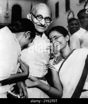 Gandhi mit seinen Enkelinnen - Neu-Delhi, Indien. Mahatma Mohandas Gandhi wird kurz vor seinem 78. Geburtstag mit seinen Enkeltöchtern Mani (links) und Mrs. Ava Gandhi vor dem Birla House abgebildet. Gandhi wurde am 30. Januar 1948 ermordet, als er zu seinen Abendgottesdiensten im Birla House ging. Er starb in den Armen Manis, ohne ein Wort zu sprechen. Foto, ausgestellt am 2. Oktober 1969, zum 100. Geburtstag. Stockfoto