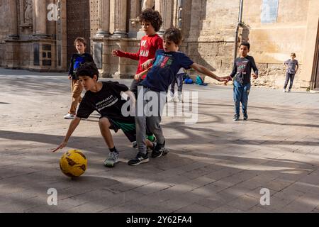 Kinder spielen Futbol in den Straßen von Valencia, Spanien. Stockfoto