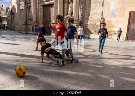 Kinder spielen Futbol in den Straßen von Valencia, Spanien. Stockfoto