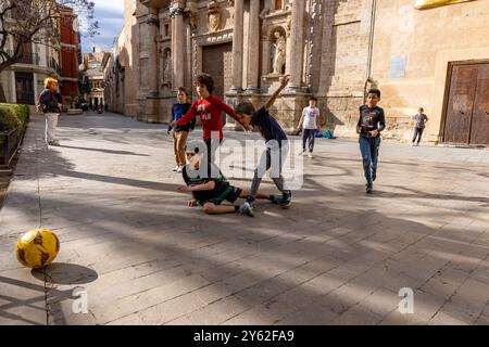 Kinder spielen Futbol in den Straßen von Valencia, Spanien. Stockfoto