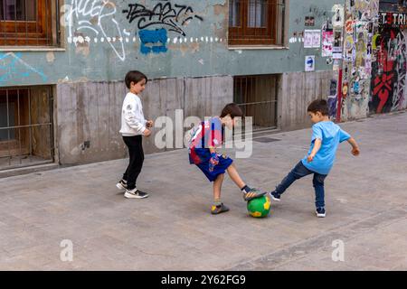 Kinder spielen Futbol in den Straßen von Valencia, Spanien. Stockfoto