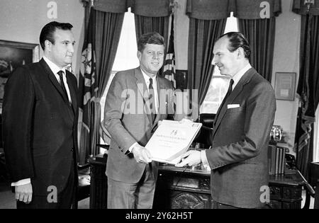 Der britische Botschafter in Washington , Sir David Ormsby Gore , präsentiert Präsident John F. Kennedy im Weißen Haus mit Aufnahmen ausgewählter Reden des britischen Premierministers Winston Churchill . Die Aufnahmen bestehen aus den Höhepunkten von 24 Reden Churchills von der Zeit Münchens bis zum Ende des Zweiten Weltkriegs . Links ist Don Kirshner , Vice President , Music and Recording , Columbia Pictures , Washington DC , USA . 31. Oktober 1963 Stockfoto