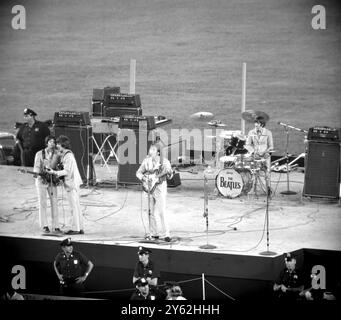 New York, USA: Die Abgöttin für die britische Beat Group - die Beatles - geht trotz des Boykotts einiger amerikanischer Organisationen weiter. Unser Bild zeigt, wie die Gruppe während ihres Auftritts im Shea Stadium am 23. August in New York Polizeischutz erhält Links nach rechts: Paul McCartney; George Harrison; John Lennon und Ringo Star. Um die Beatles vor den schreienden Fans zu schützen, errichteten die Polizisten drei Reihen von Barrieren und die Gruppe arrrierte und verließ sie mit einem gepanzerten Wagen. 25. August 1966 Stockfoto