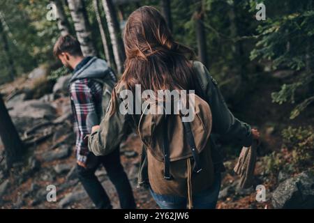 Der beste Weg, um der Stadt zu entkommen. Rückansicht von jungen Paaren, die gemeinsam im Wald wandern und dabei ihre Reise genießen Stockfoto