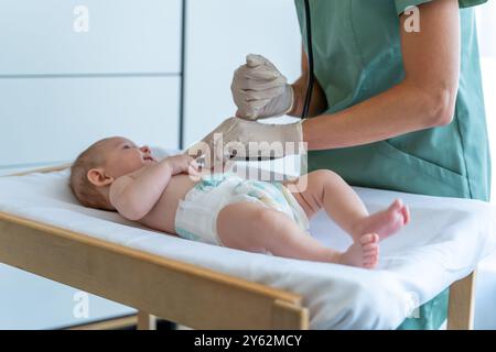 Der Arzt untersucht Neugeborene während eines geplanten Termins in der Klinik Stockfoto